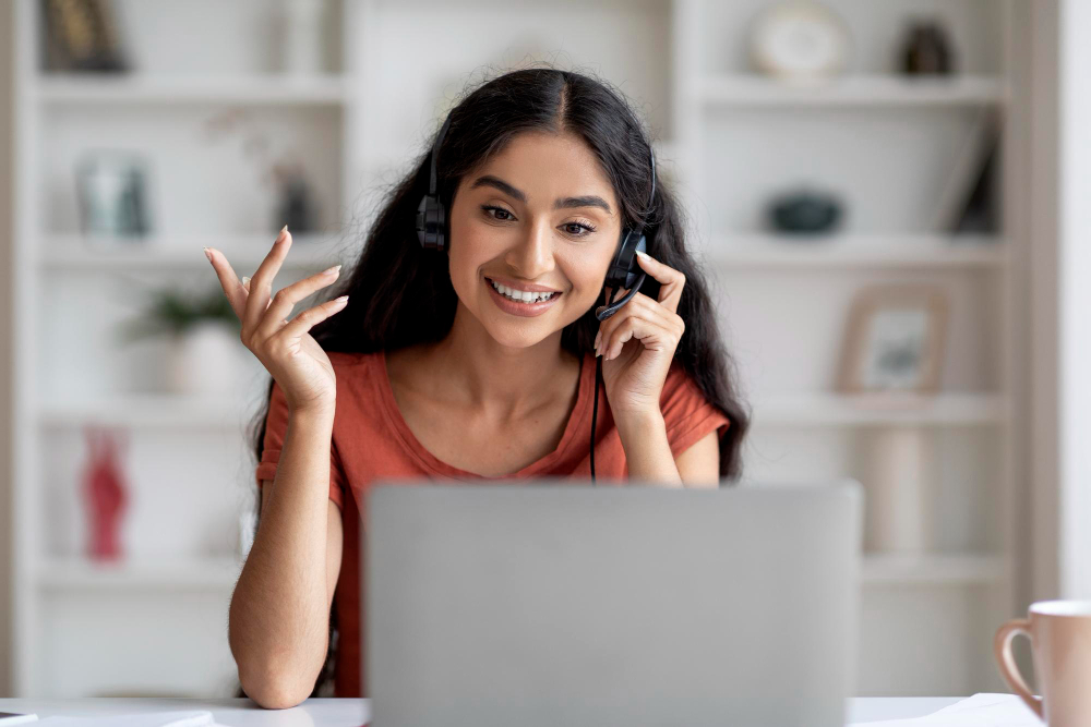 A professional with a headset smiling while working on a laptop, symbolizing seamless communication and support from Extend Your Team.